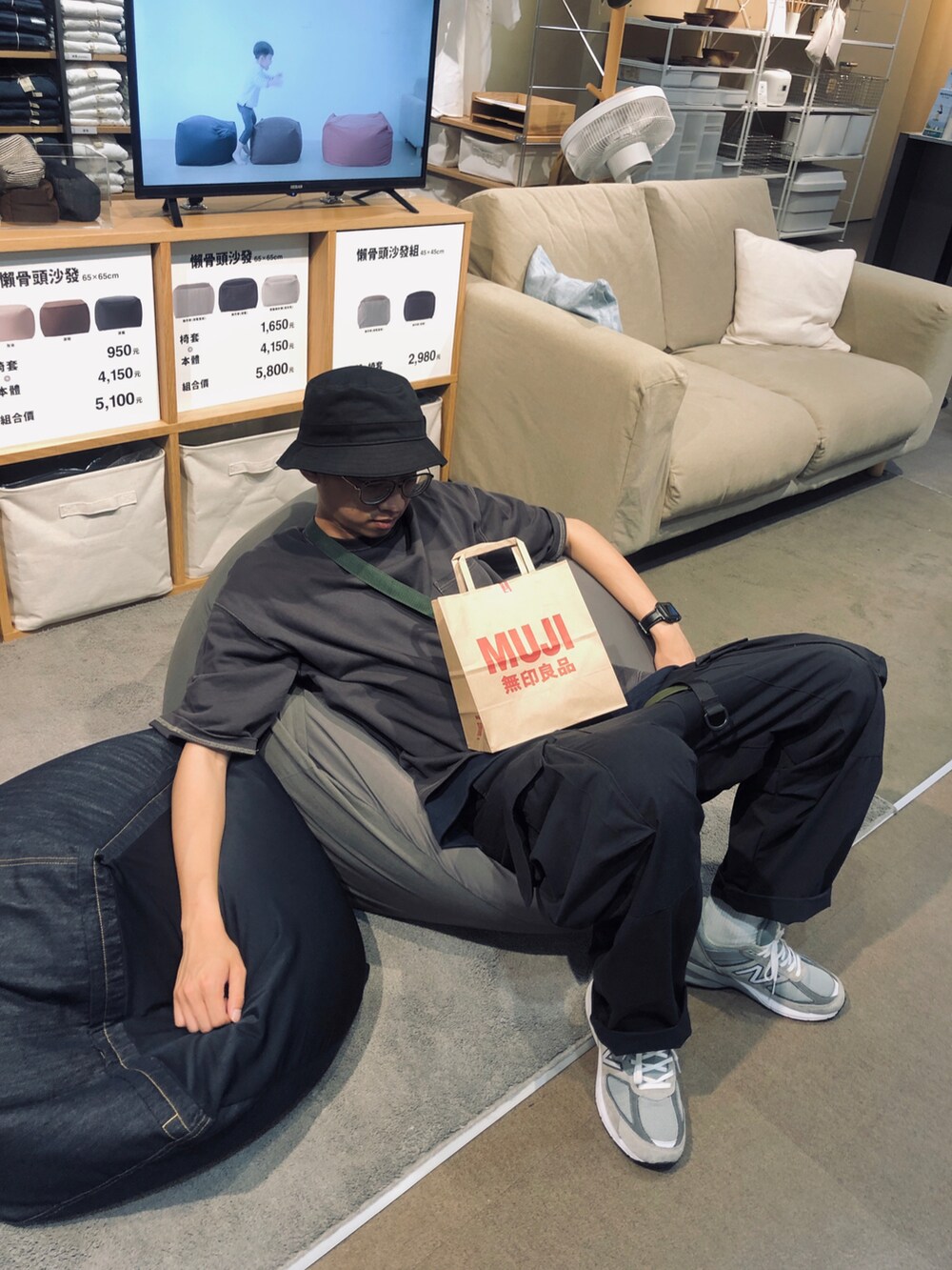 グレー系のトップス、ブラック系のパンツ、グレー系のスニーカーを着用したメンズの春コーディネートの2枚目の写真