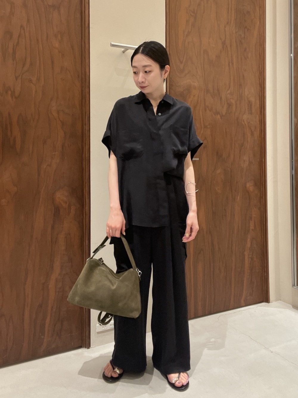 ブルー系のシャツ/ブラウス、ブラック系のその他シューズ、グリーン系のトートバッグを着用したレディースの春コーディネートの5枚目の写真