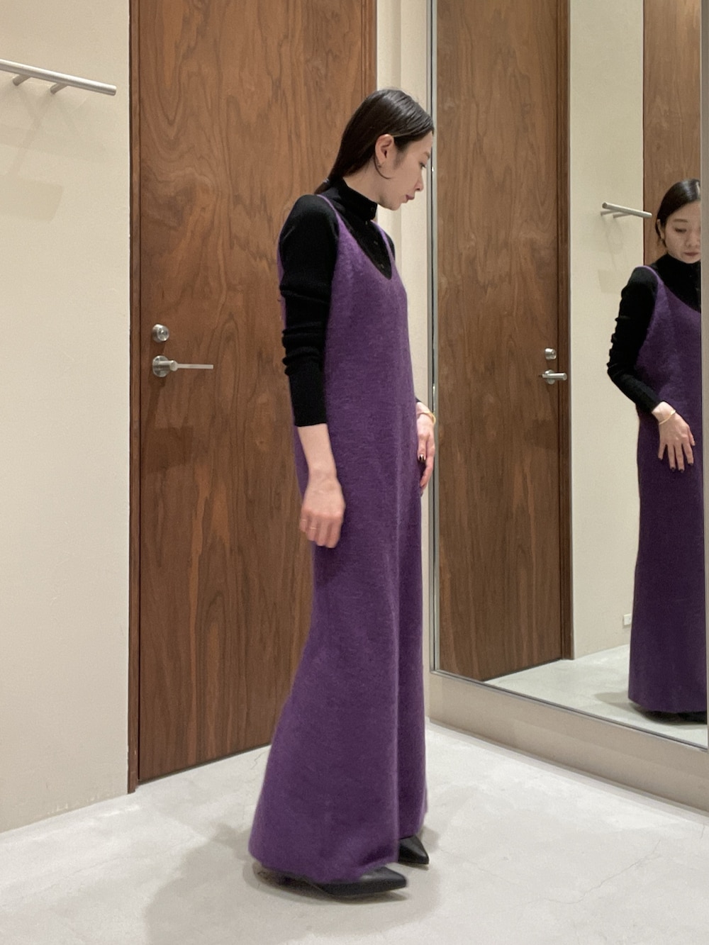 パープル系のワンピース、ブラック系のニット/セーターを着用したレディースの秋コーディネートの4枚目の写真