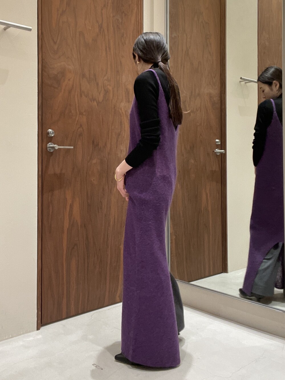 パープル系のワンピース、ブラック系のニット/セーターを着用したレディースの秋コーディネートの5枚目の写真