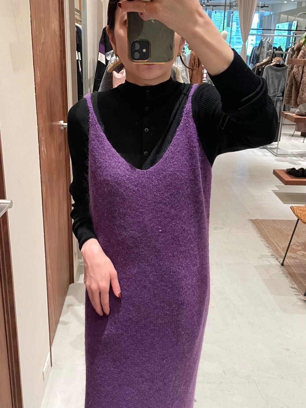 パープル系のワンピース、ブラック系のニット/セーターを着用したレディースの秋コーディネートの2枚目の写真