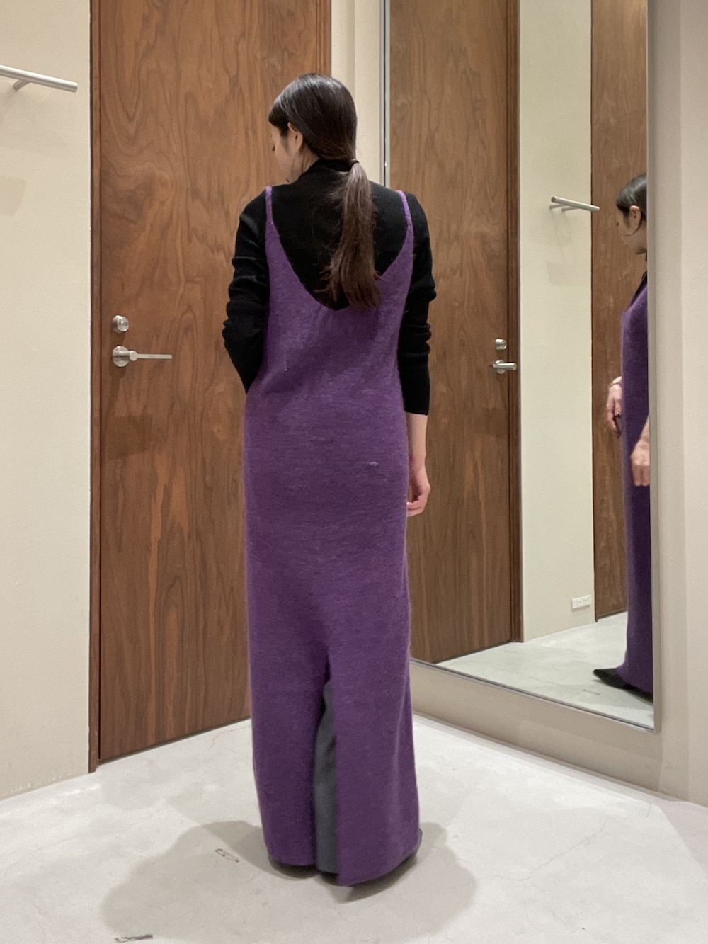 パープル系のワンピース、ブラック系のニット/セーターを着用したレディースの秋コーディネートの6枚目の写真