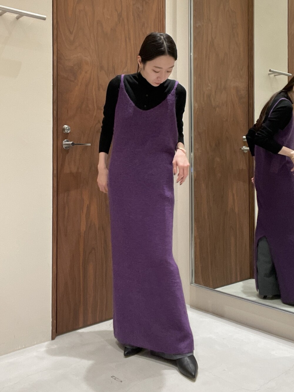 パープル系のワンピース、ブラック系のニット/セーターを着用したレディースの秋コーディネートの7枚目の写真