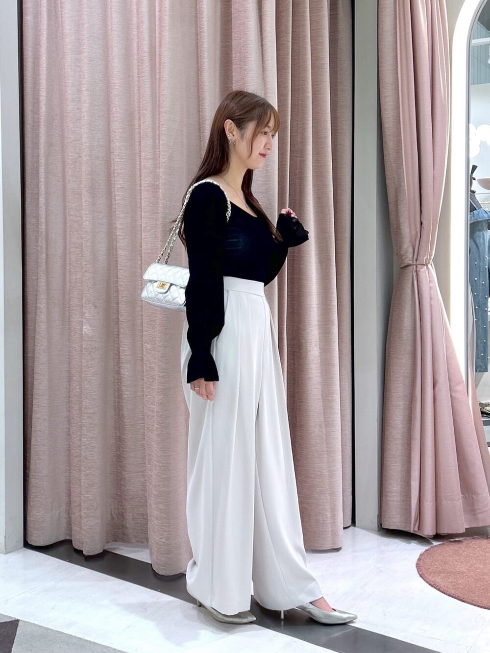 ベージュ系のスラックス、ブラック系のTシャツ/カットソーを着用したレディースの冬コーディネートの4枚目の写真