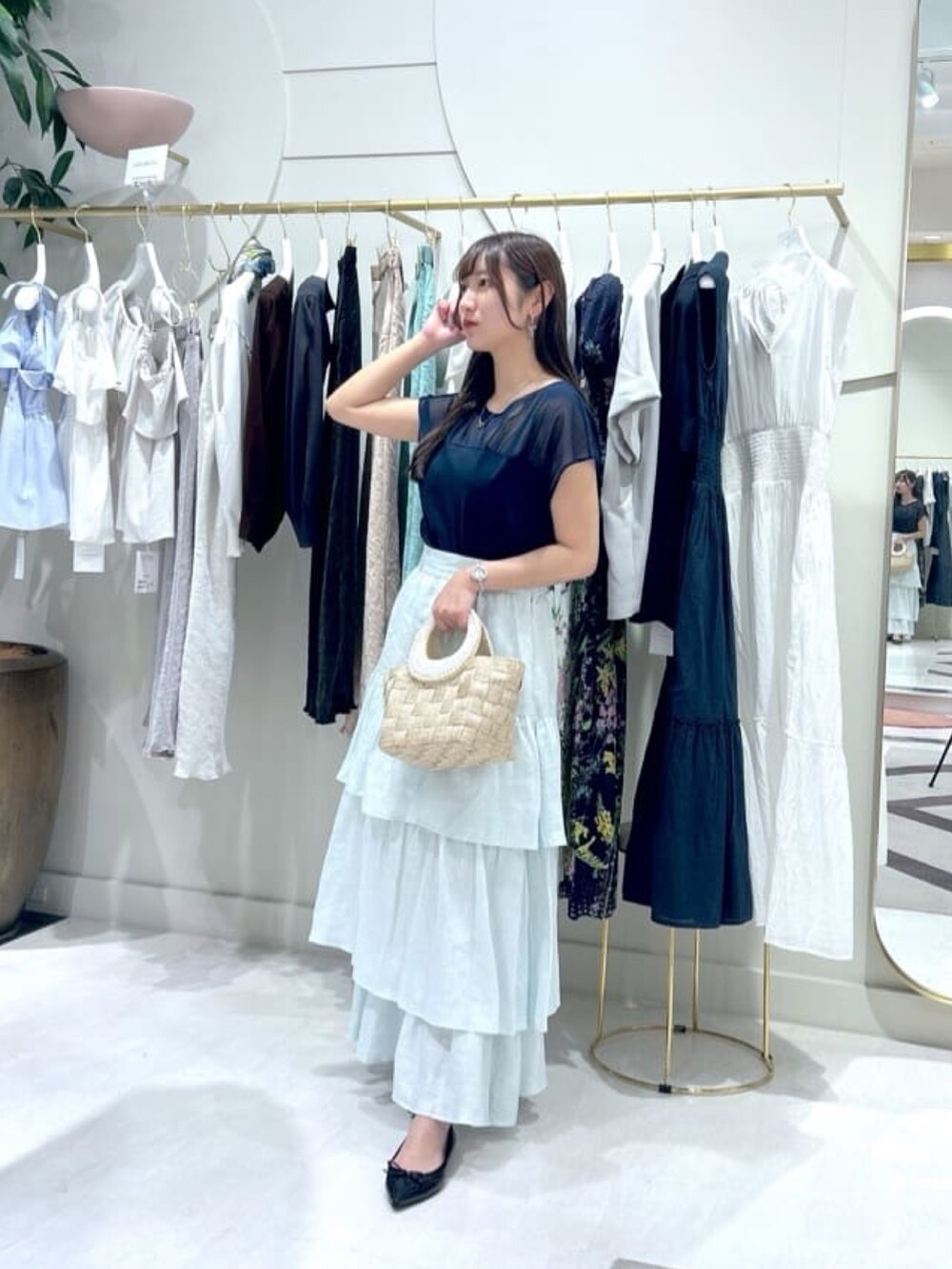 ブルー系のスカート、ブルー系のTシャツ/カットソー、ベージュ系のトートバッグを着用したレディースの夏コーディネートの3枚目の写真