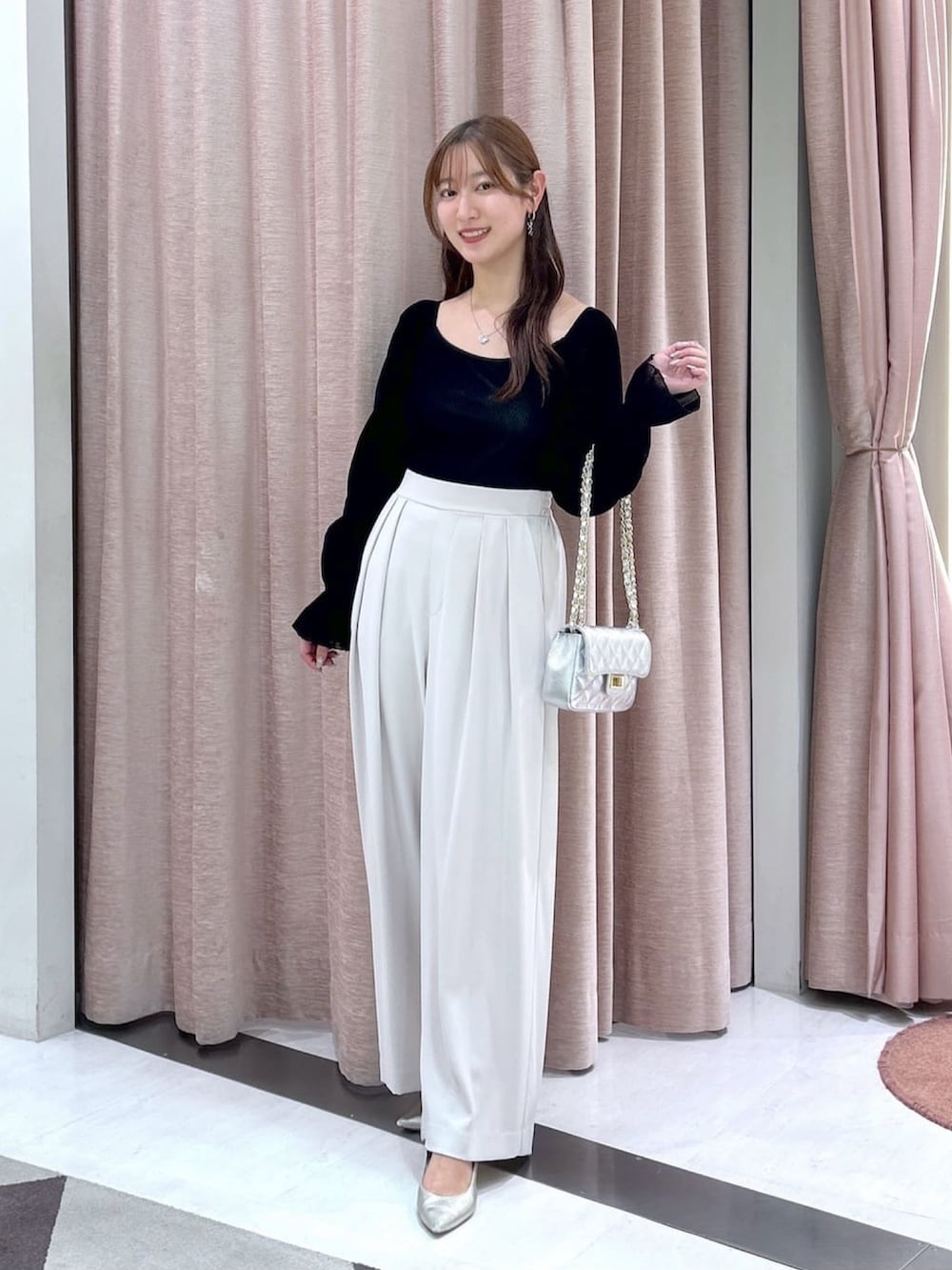 ベージュ系のスラックス、ブラック系のTシャツ/カットソーを着用したレディースの冬コーディネートの2枚目の写真