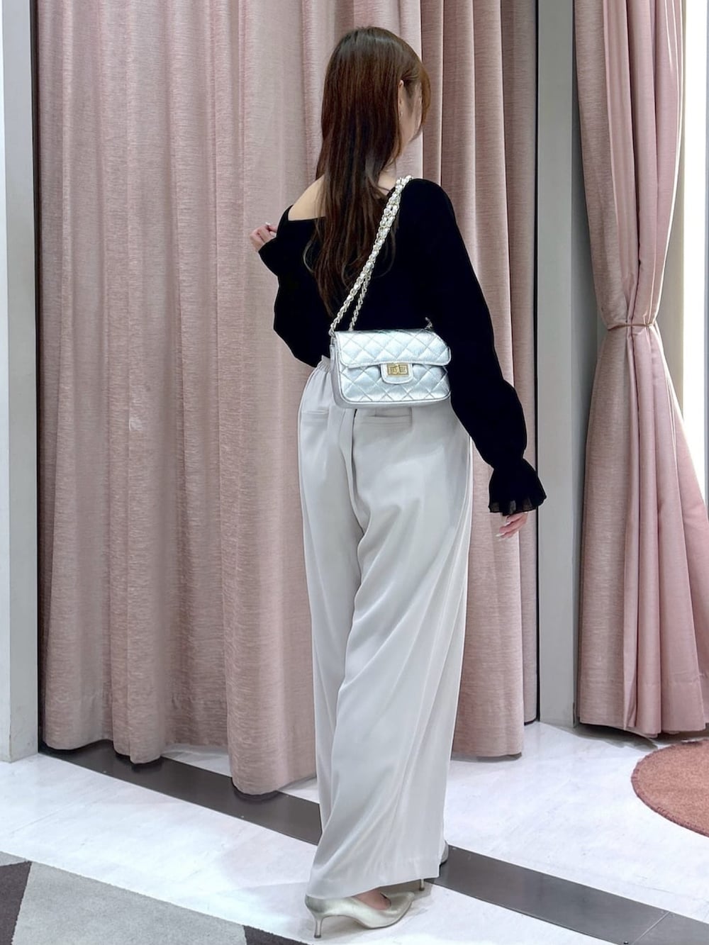 ベージュ系のスラックス、ブラック系のTシャツ/カットソーを着用したレディースの冬コーディネートの5枚目の写真