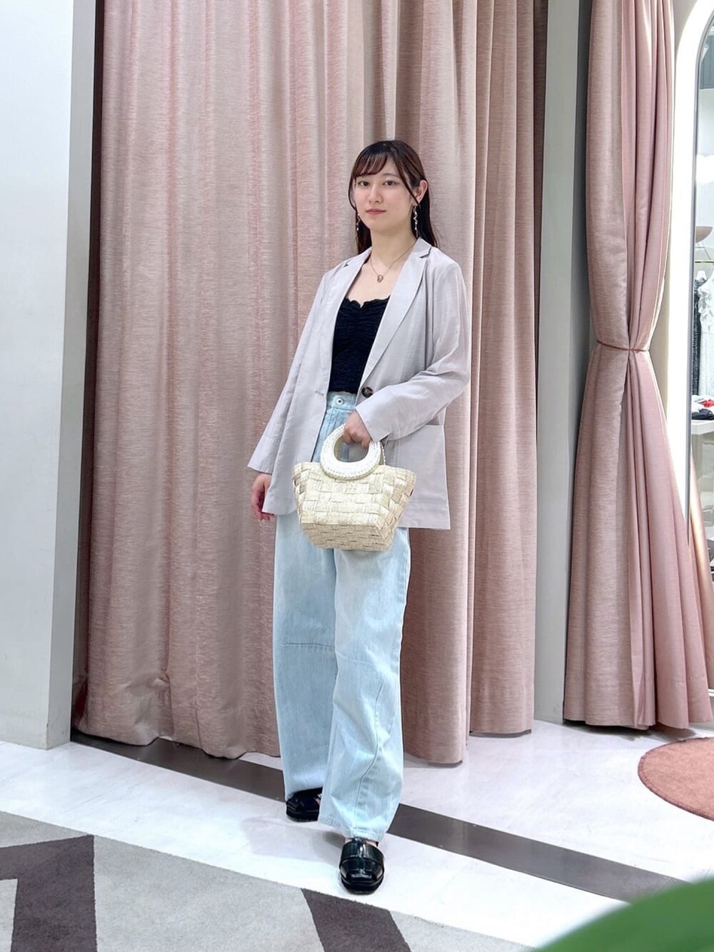 ベージュ系のテーラードジャケット、ブルー系のデニムパンツ、ブラック系のキャミソールを着用したレディースの夏コーディネートの3枚目の写真