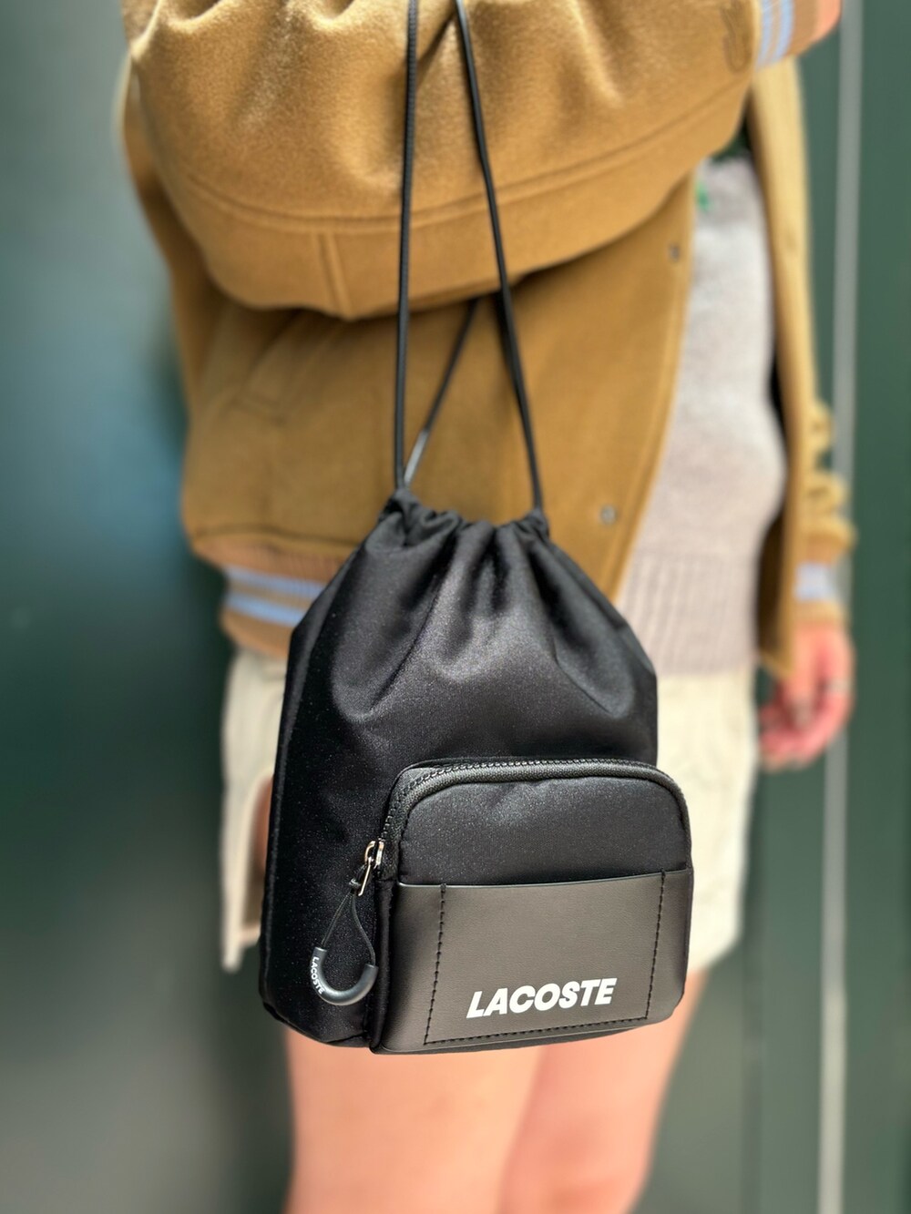 ブラウン系のブルゾン、グレー系のニット/セーター、ホワイト系のスカートを着用したレディースの夏コーディネートの6枚目の写真