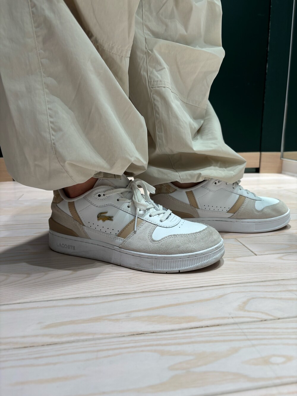 ホワイト系のスニーカー、ホワイト系のカーゴパンツ、ブルー系のクラッチバッグを着用したレディースの夏コーディネートの5枚目の写真