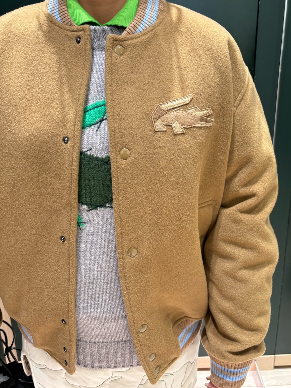 ブラウン系のブルゾン、グレー系のニット/セーター、ホワイト系のスカートを着用したレディースの夏コーディネートの5枚目の写真