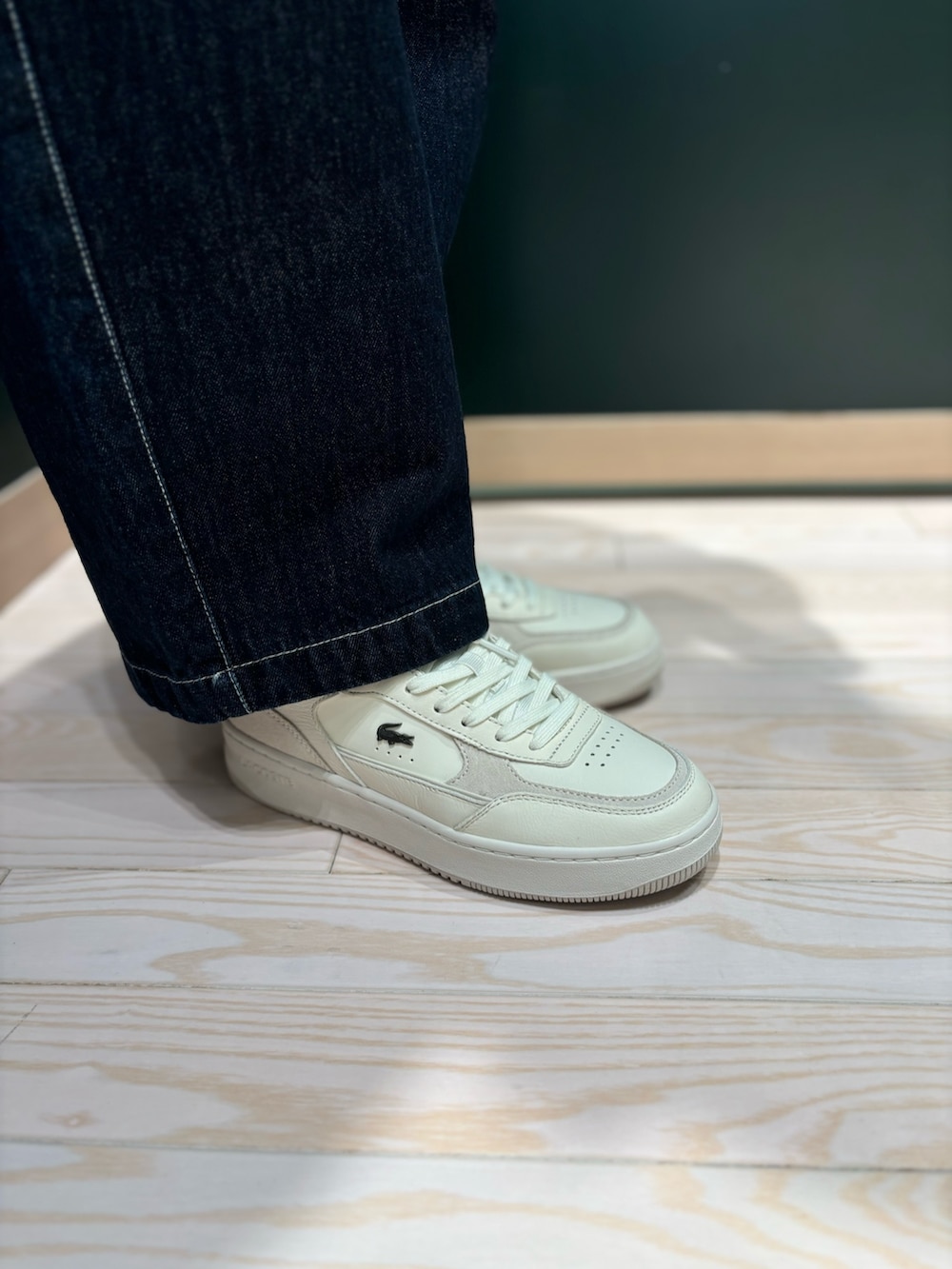 グレー系のニット/セーター、ホワイト系のスニーカー、ブルー系のデニムパンツを着用したレディースの秋コーディネートの6枚目の写真