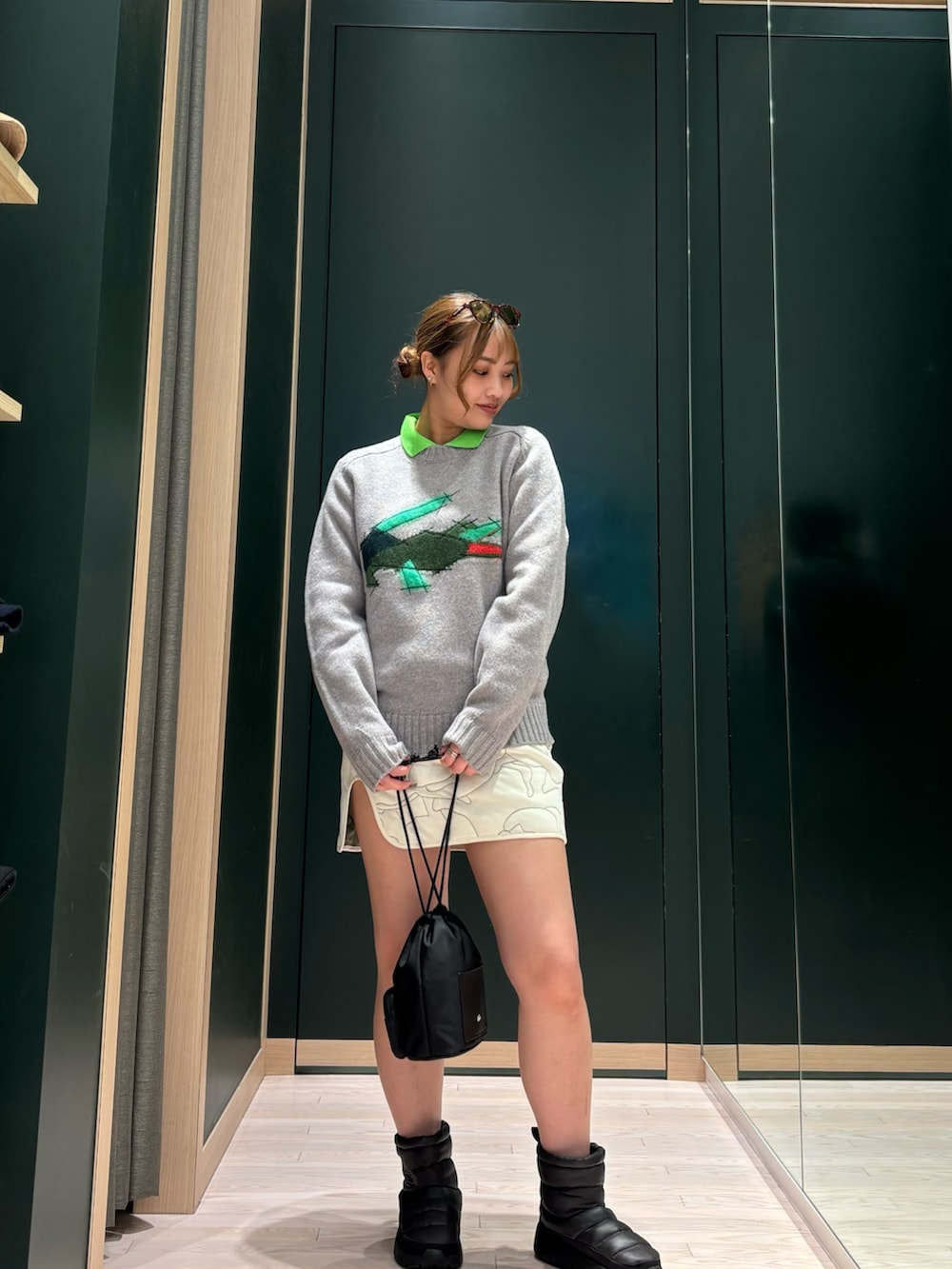 ブラウン系のブルゾン、グレー系のニット/セーター、ホワイト系のスカートを着用したレディースの夏コーディネートの2枚目の写真