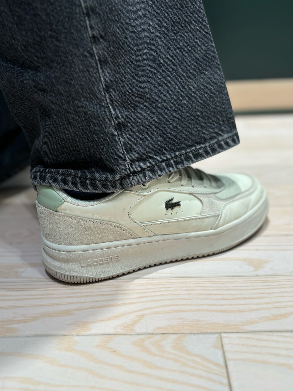 ホワイト系のパーカー、ホワイト系のスニーカー、ブラック系のデニムパンツを着用したレディースの秋コーディネートの5枚目の写真