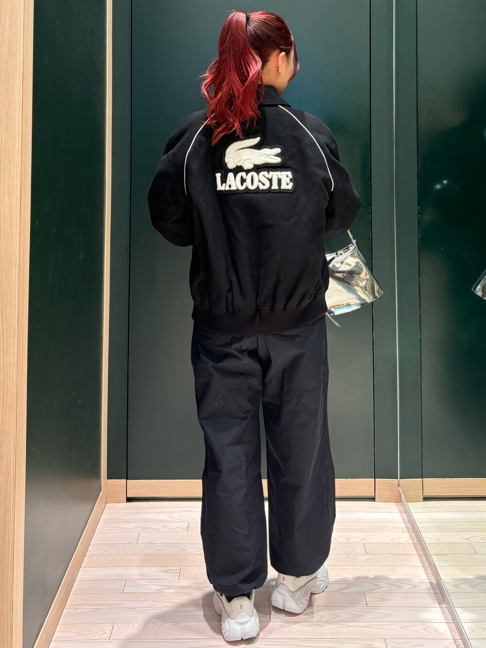 ホワイト系のスニーカー、ブラック系のブルゾン、ホワイト系のTシャツ/カットソーを着用したレディースの冬コーディネートの2枚目の写真