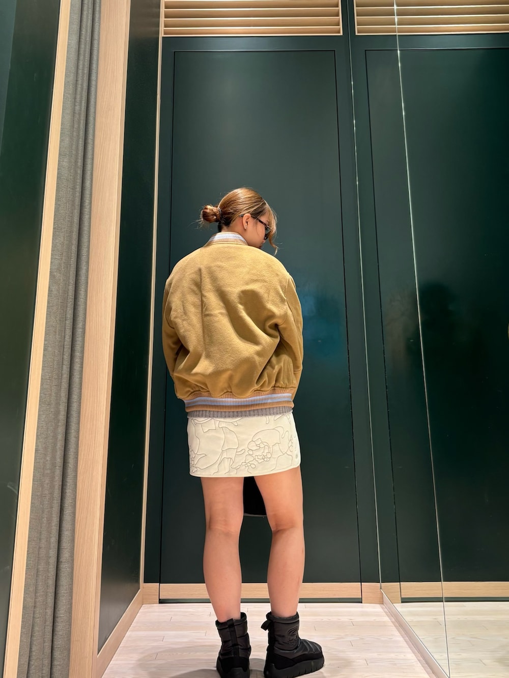 ブラウン系のブルゾン、グレー系のニット/セーター、ホワイト系のスカートを着用したレディースの夏コーディネートの3枚目の写真