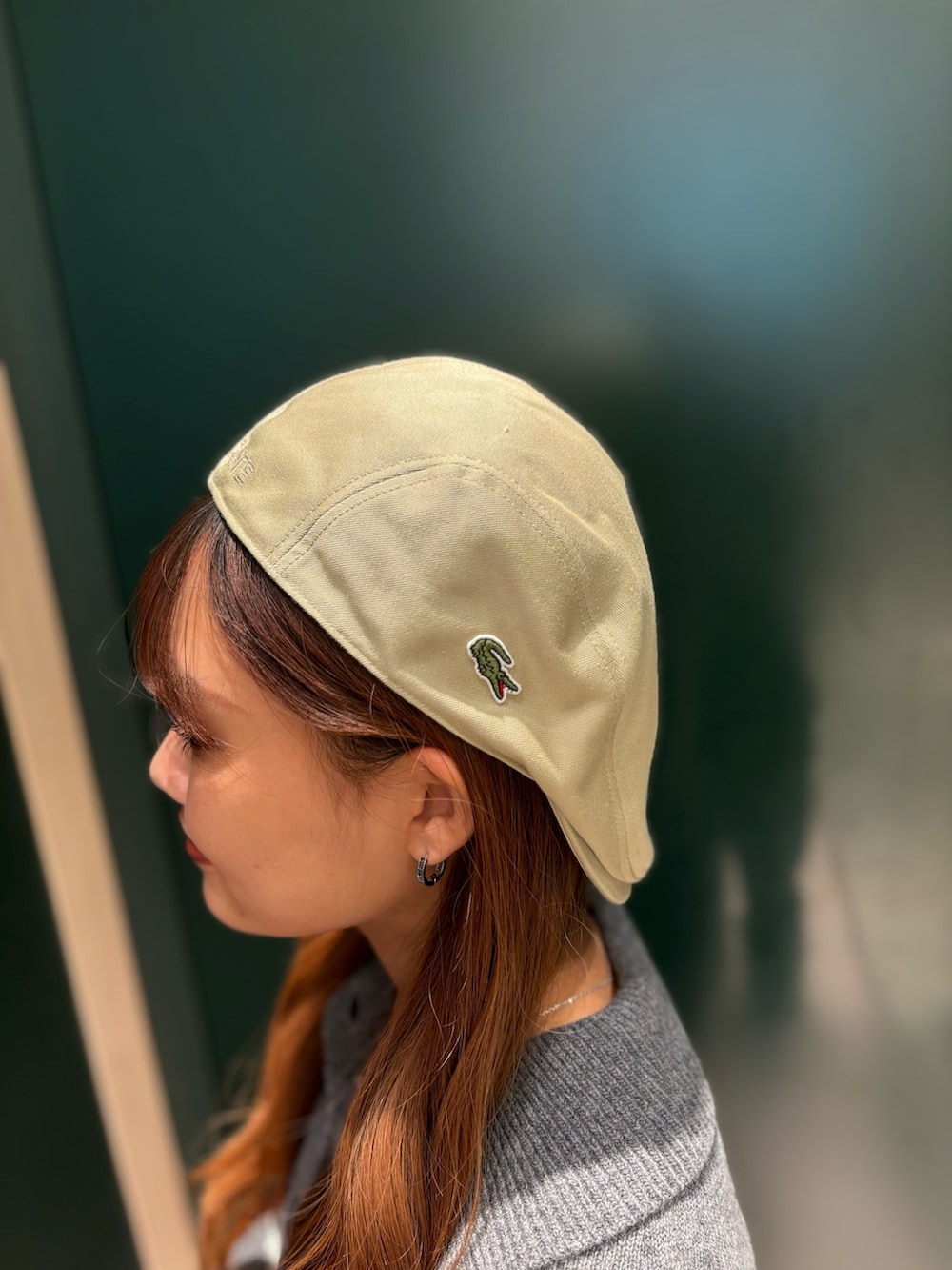 グレー系のニット/セーター、ホワイト系のスニーカー、ブルー系のデニムパンツを着用したレディースの秋コーディネートの5枚目の写真