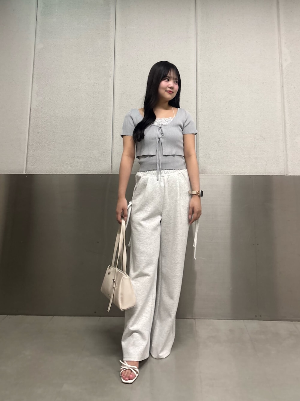 ブルー系のカーディガン/ボレロ、ベージュ系のスウェットパンツ、ホワイト系のサンダルを着用したレディースの春コーディネートの2枚目の写真