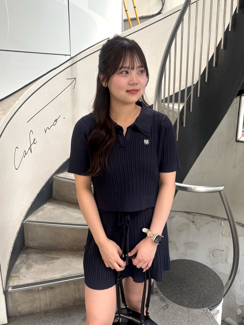 ブルー系のニット/セーター、ブルー系のスカート、ブラック系のボストンバッグを着用したレディースの春コーディネートの4枚目の写真