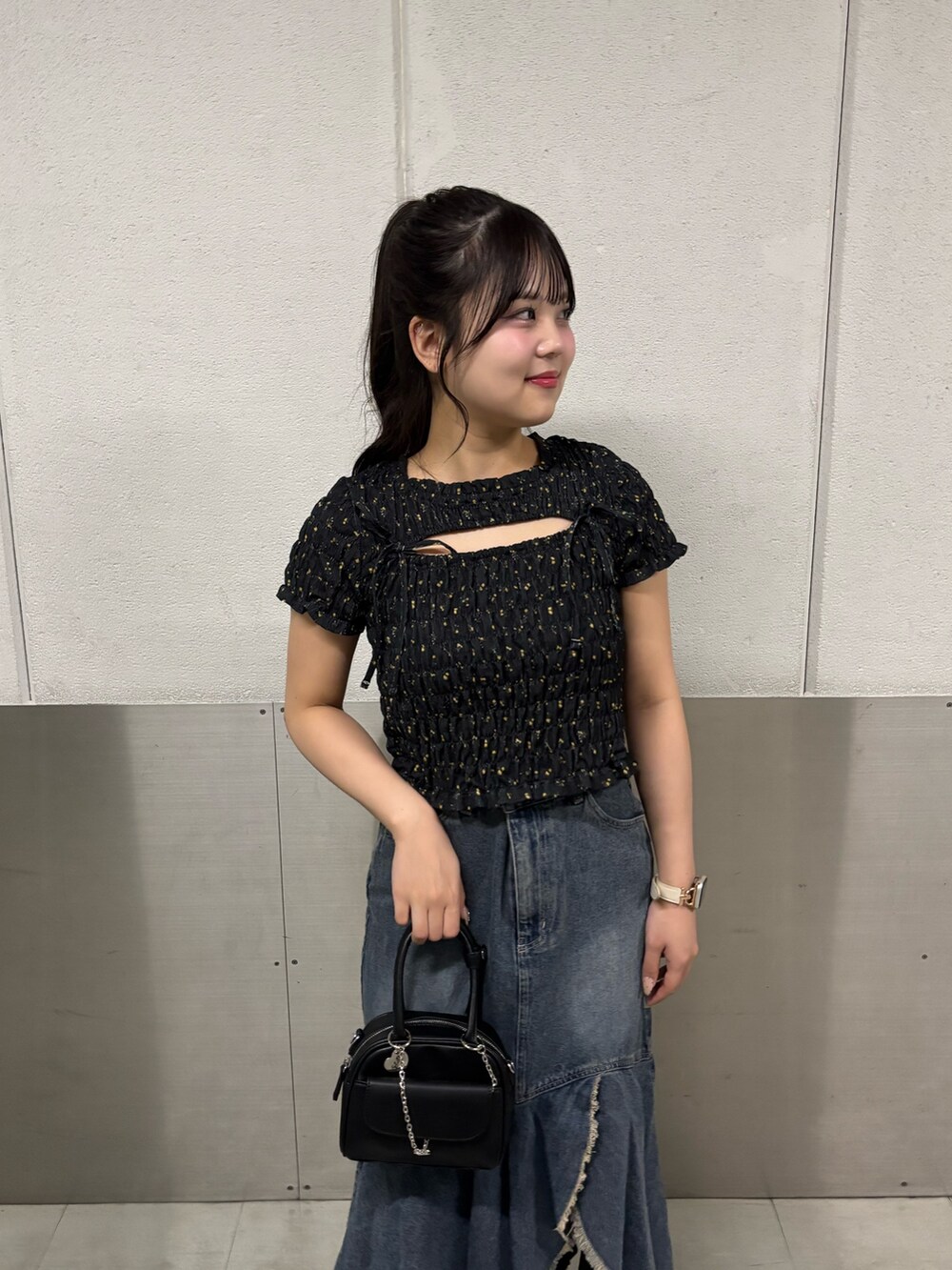 ブルー系のスカート、ブラック系のTシャツ/カットソー、ブラック系のボストンバッグを着用したレディースの夏コーディネートの3枚目の写真