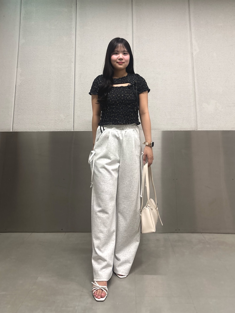 ブラック系のTシャツ/カットソー、ホワイト系のサンダル、ホワイト系のボストンバッグを着用したレディースの春コーディネートの2枚目の写真