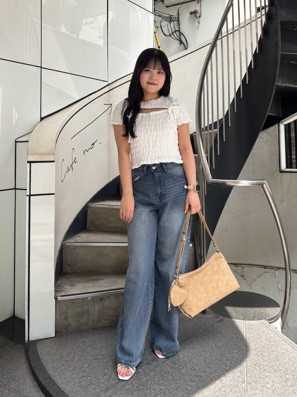 ホワイト系のTシャツ/カットソー、ブルー系のデニムパンツ、ホワイト系のサンダルを着用したレディースの春コーディネートの2枚目の写真