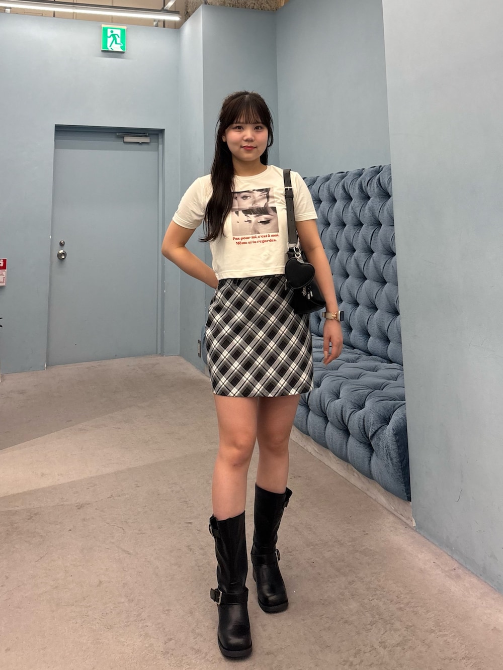 ホワイト系のTシャツ/カットソー、ブラック系のスカート、ブラック系のブーツを着用したレディースの夏コーディネートの2枚目の写真