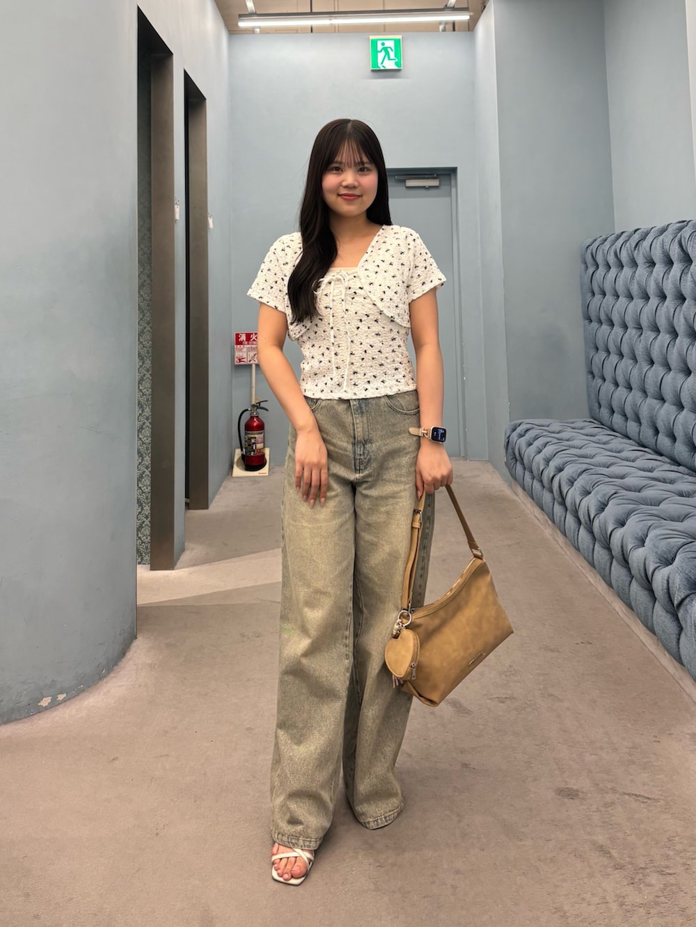 ホワイト系のTシャツ/カットソー、ブルー系のデニムパンツ、ベージュ系のショルダーバッグを着用したレディースの夏コーディネートの2枚目の写真