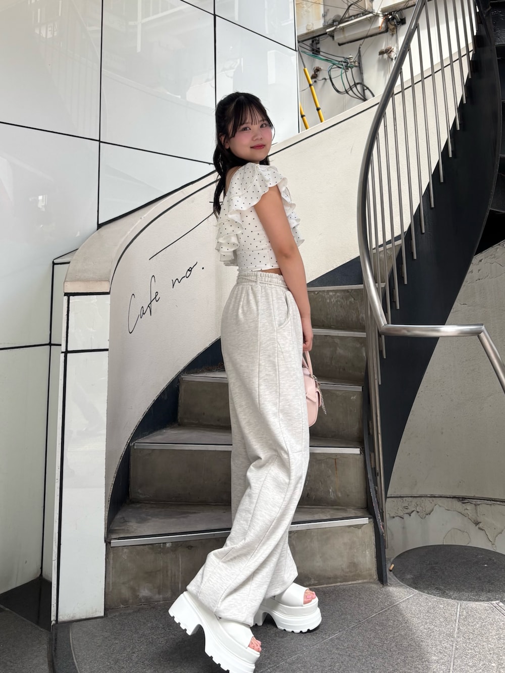 ベージュ系のその他パンツ、ピンク系のボストンバッグ、ホワイト系のサンダルを着用したレディースの夏コーディネートの3枚目の写真