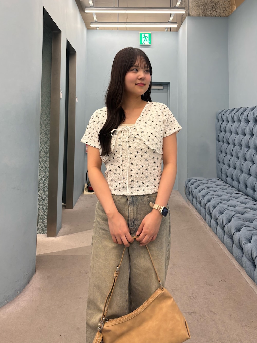 ホワイト系のTシャツ/カットソー、ブルー系のデニムパンツ、ベージュ系のショルダーバッグを着用したレディースの夏コーディネートの4枚目の写真