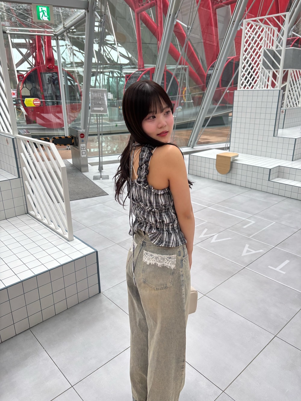 ブラック系のワンピース、ブルー系のデニムパンツ、ブラック系のサンダルを着用したレディースの春コーディネートの4枚目の写真