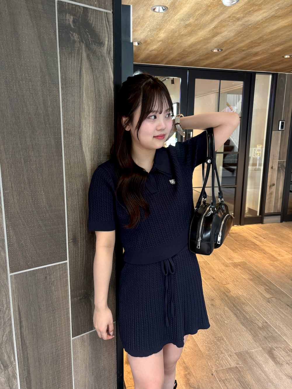 ブルー系のニット/セーター、ブルー系のスカート、ブラック系のボストンバッグを着用したレディースの春コーディネートの5枚目の写真