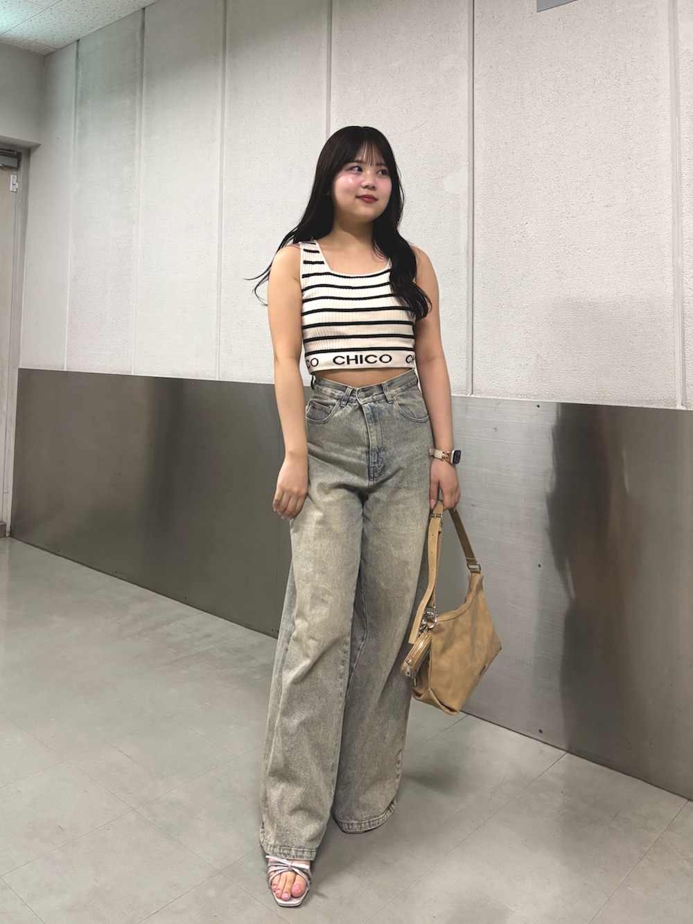 ホワイト系のタンクトップ、ブルー系のデニムパンツ、ホワイト系のサンダルを着用したレディースの春コーディネートの2枚目の写真