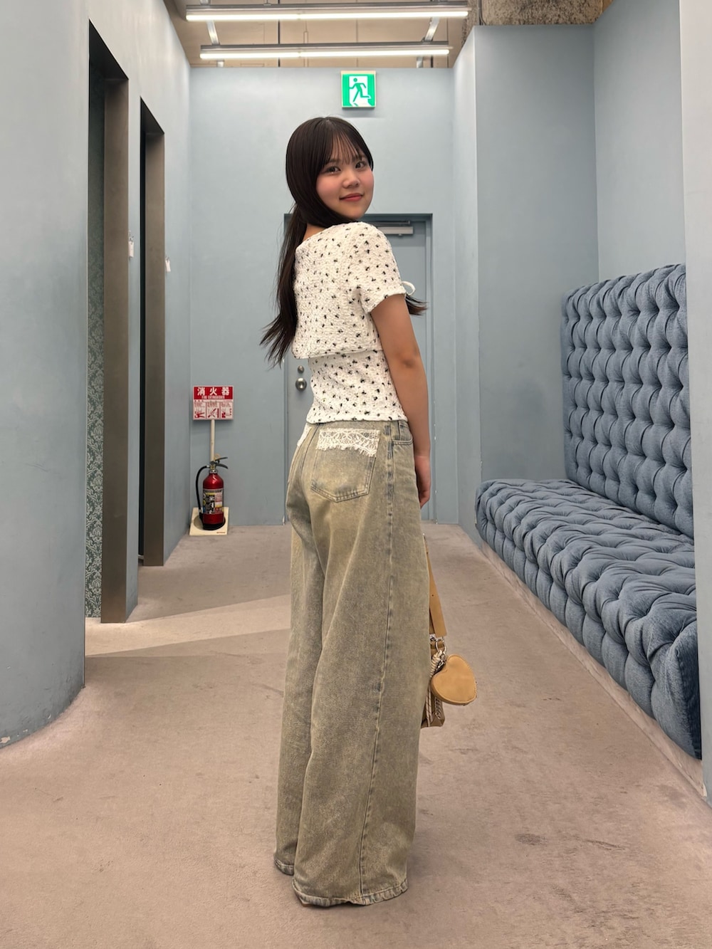 ホワイト系のTシャツ/カットソー、ブルー系のデニムパンツ、ベージュ系のショルダーバッグを着用したレディースの夏コーディネートの3枚目の写真