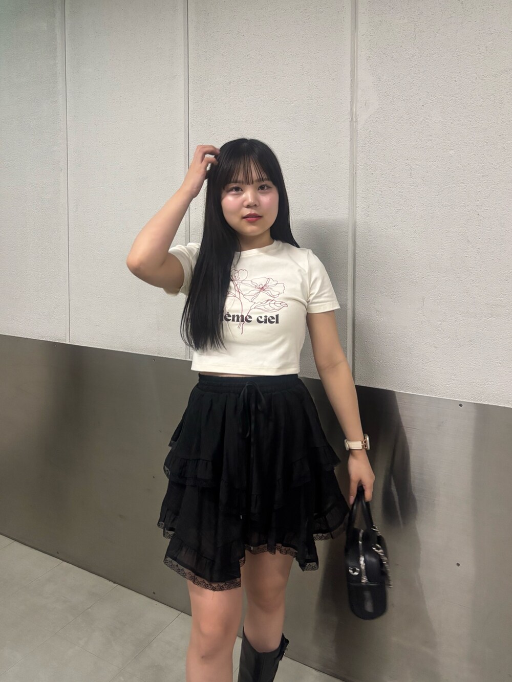 ブラック系のブーツ、ブラック系のボストンバッグ、ブラック系のスカートを着用したレディースの春コーディネートの3枚目の写真