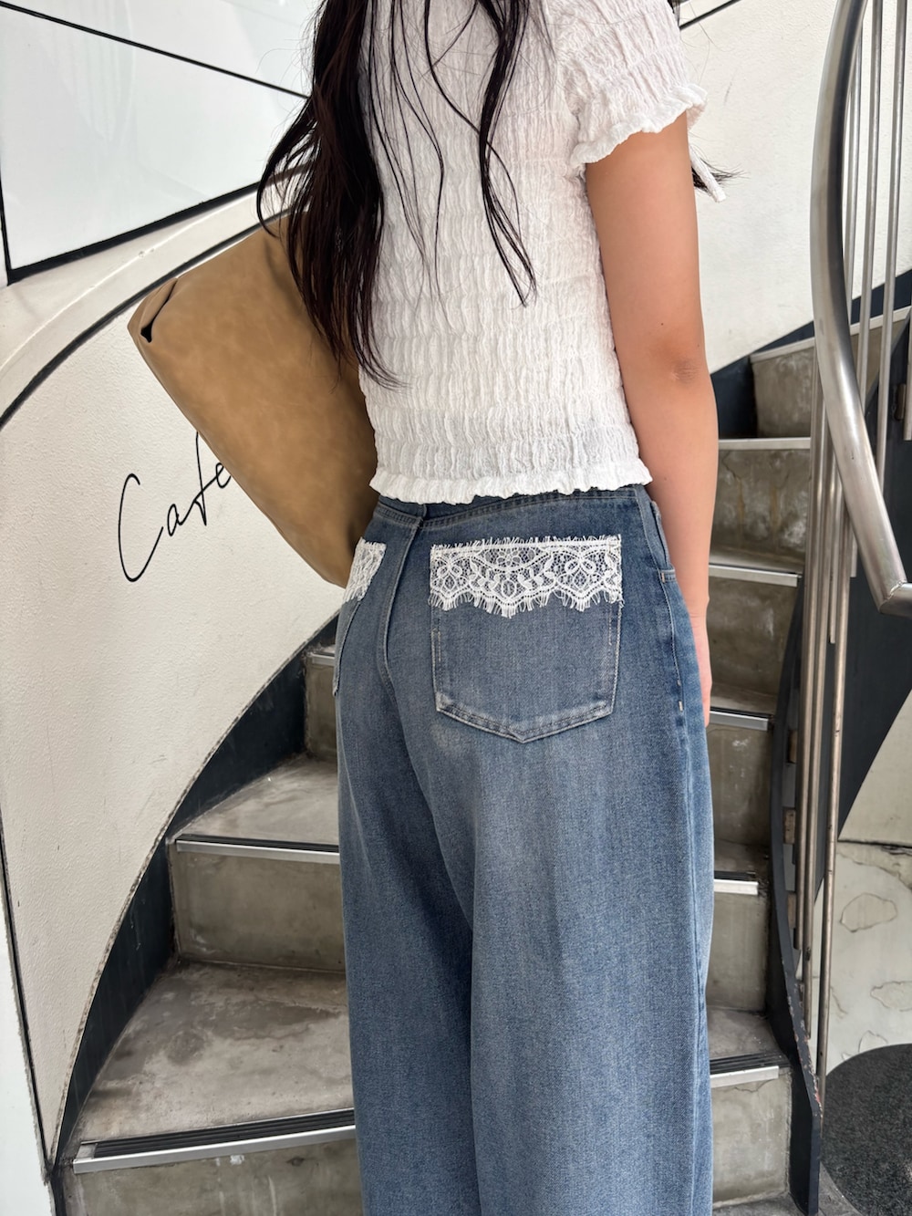 ホワイト系のTシャツ/カットソー、ブルー系のデニムパンツ、ホワイト系のサンダルを着用したレディースの春コーディネートの5枚目の写真