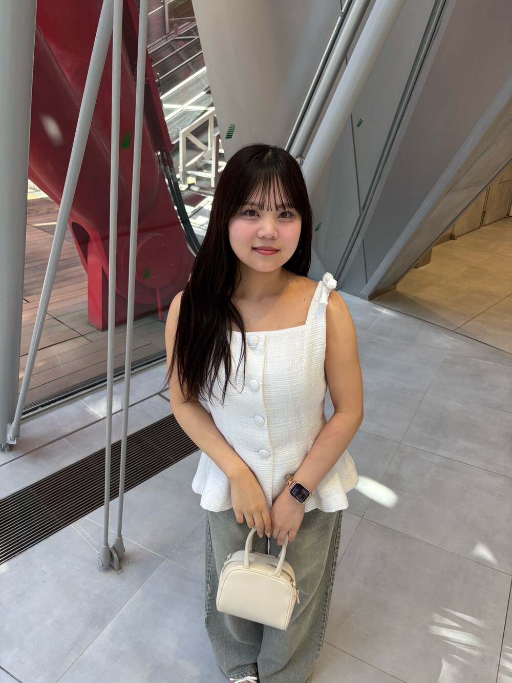 ホワイト系のベスト、ブルー系のデニムパンツ、ホワイト系のサンダルを着用したレディースの夏コーディネートの4枚目の写真