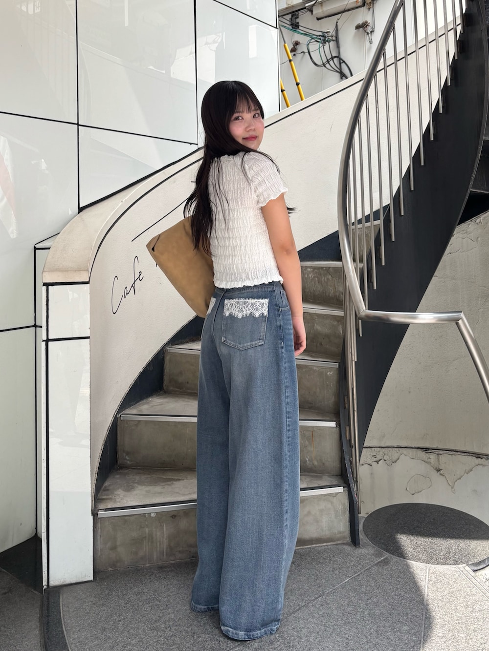 ホワイト系のTシャツ/カットソー、ブルー系のデニムパンツ、ホワイト系のサンダルを着用したレディースの春コーディネートの6枚目の写真