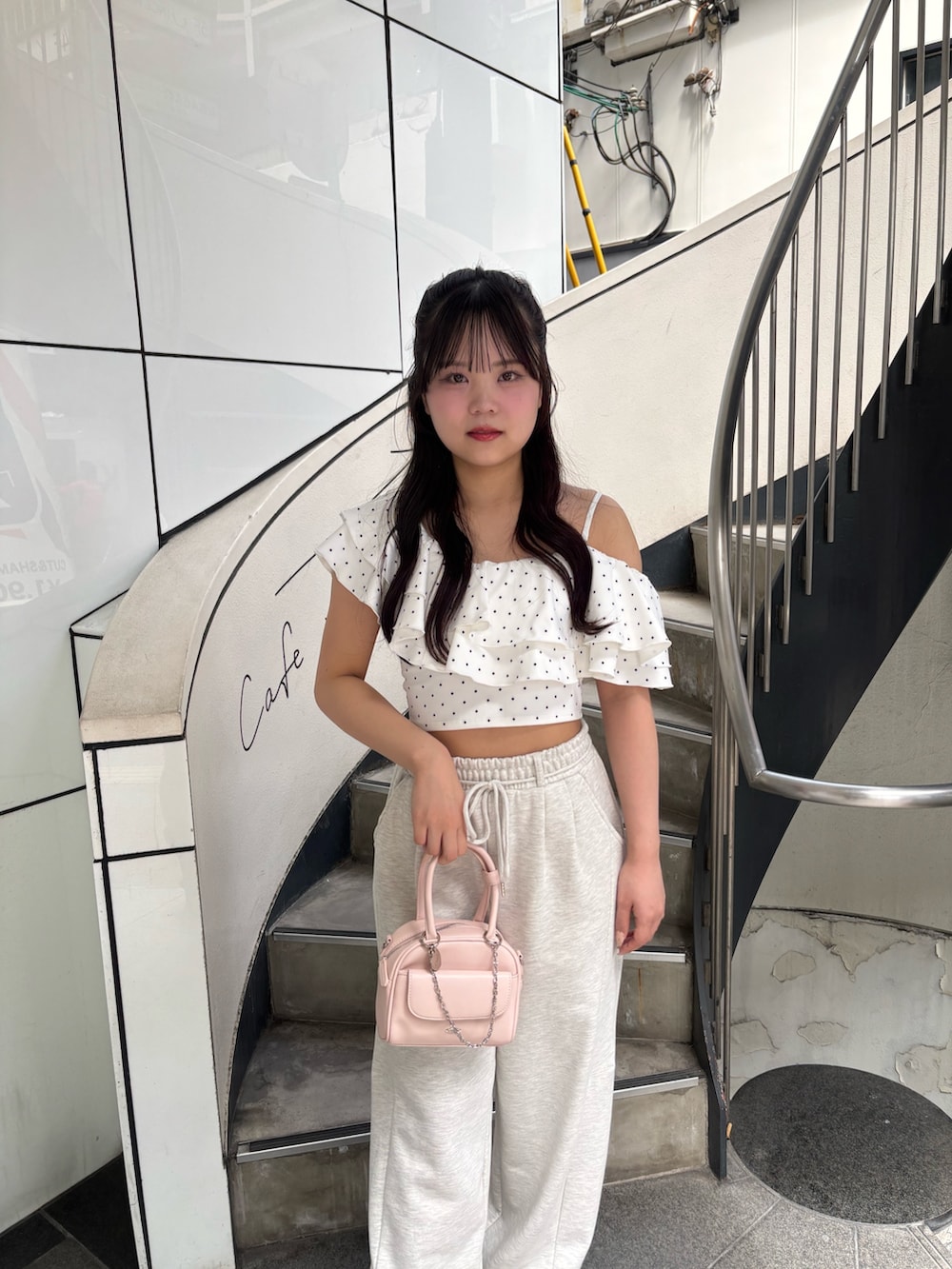 ベージュ系のその他パンツ、ピンク系のボストンバッグ、ホワイト系のサンダルを着用したレディースの夏コーディネートの2枚目の写真