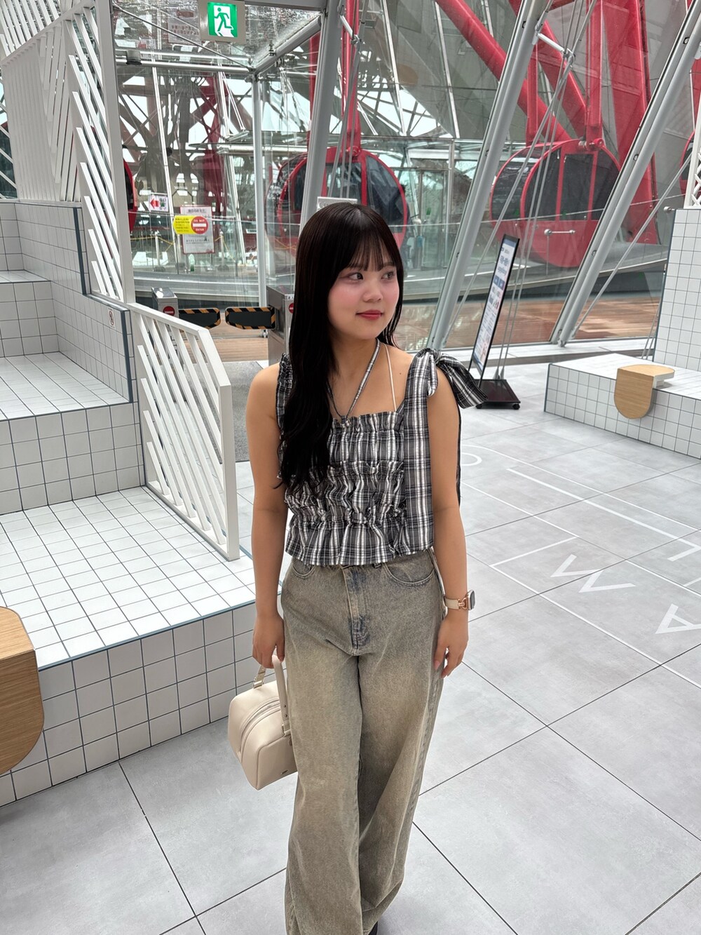 ブラック系のワンピース、ブルー系のデニムパンツ、ブラック系のサンダルを着用したレディースの春コーディネートの3枚目の写真