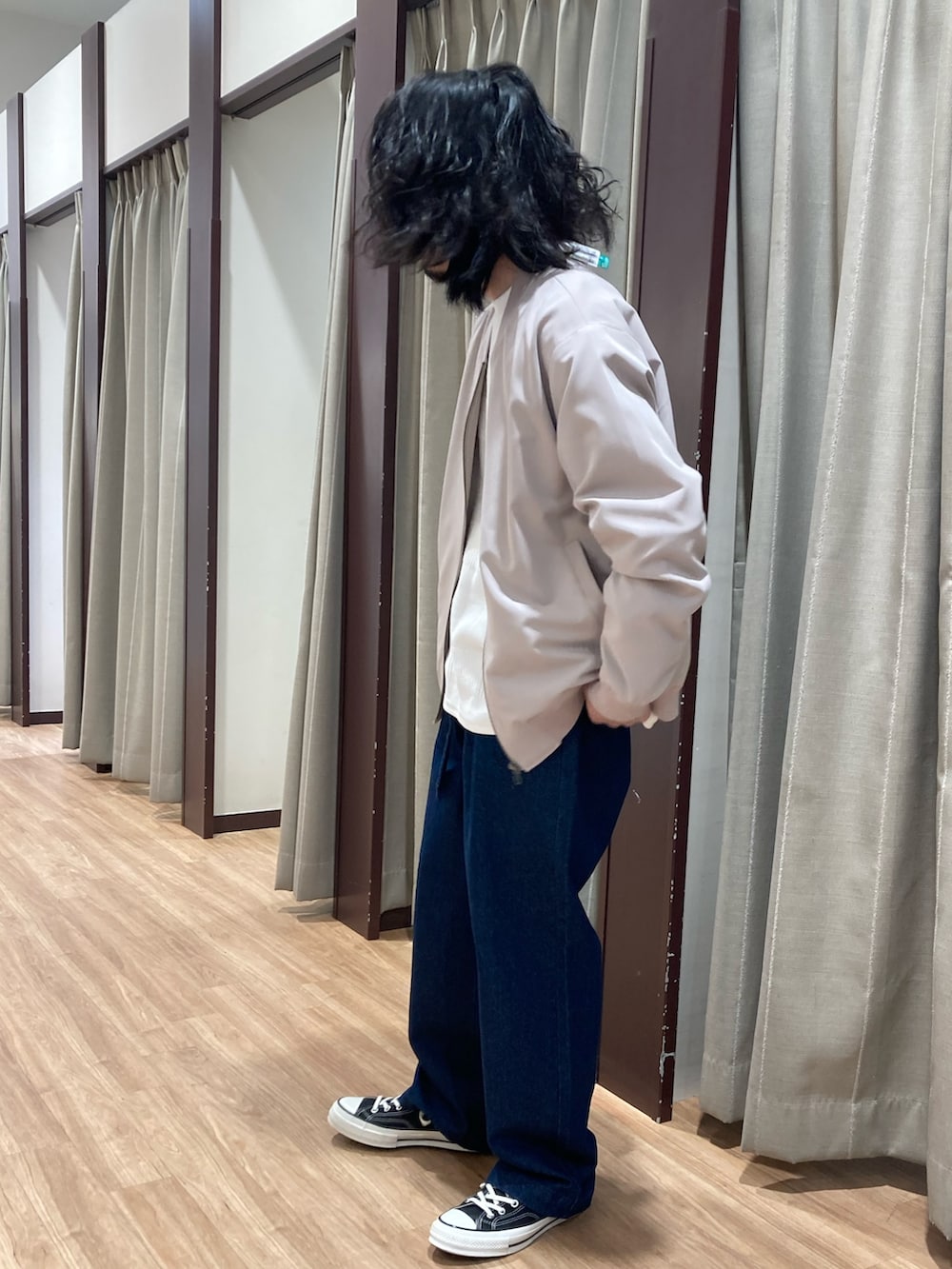 ベージュ系のブルゾン、ホワイト系のスウェット、ブルー系のデニムパンツを着用したメンズの春コーディネートの2枚目の写真