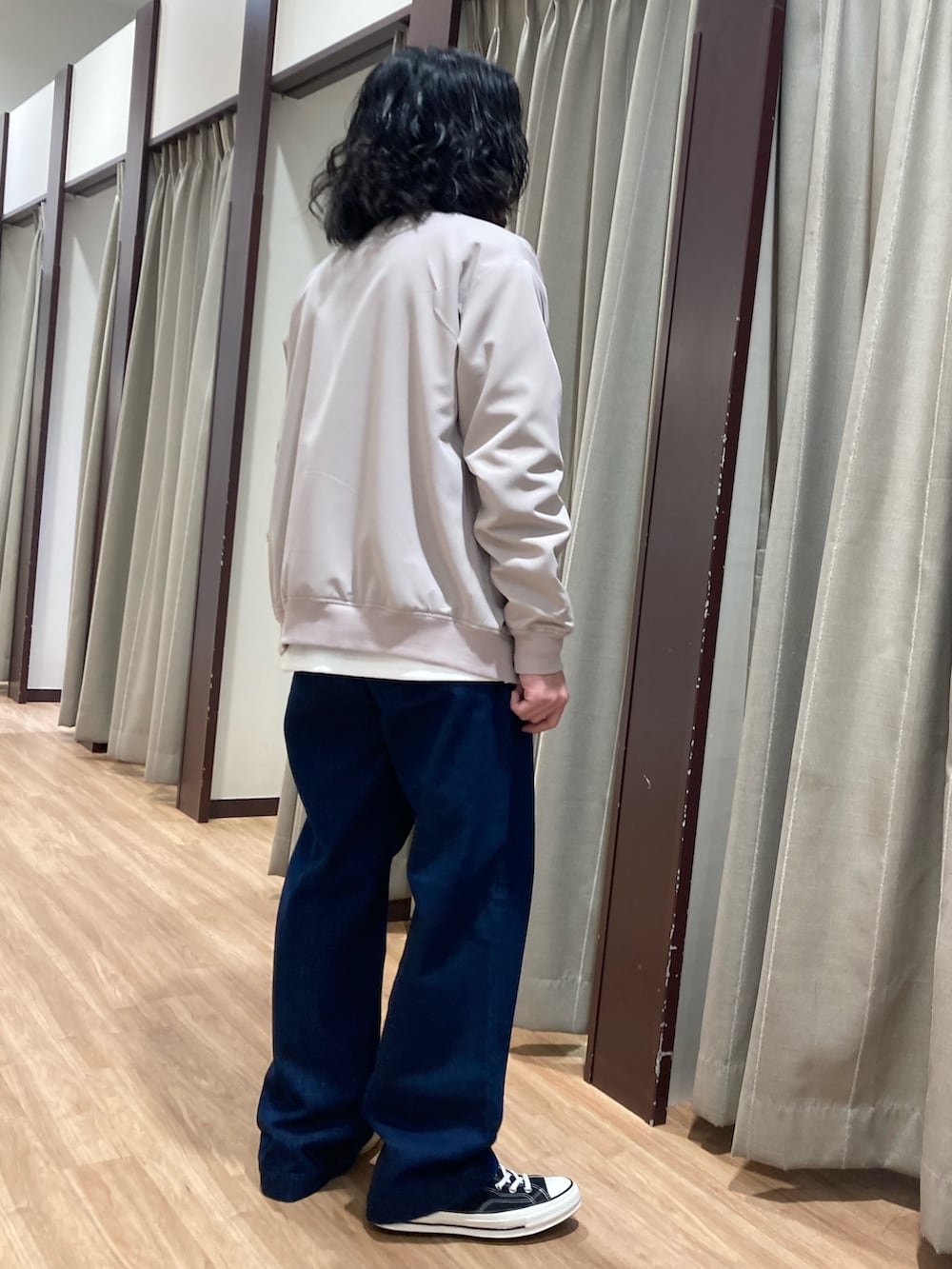 ベージュ系のブルゾン、ホワイト系のスウェット、ブルー系のデニムパンツを着用したメンズの春コーディネートの3枚目の写真