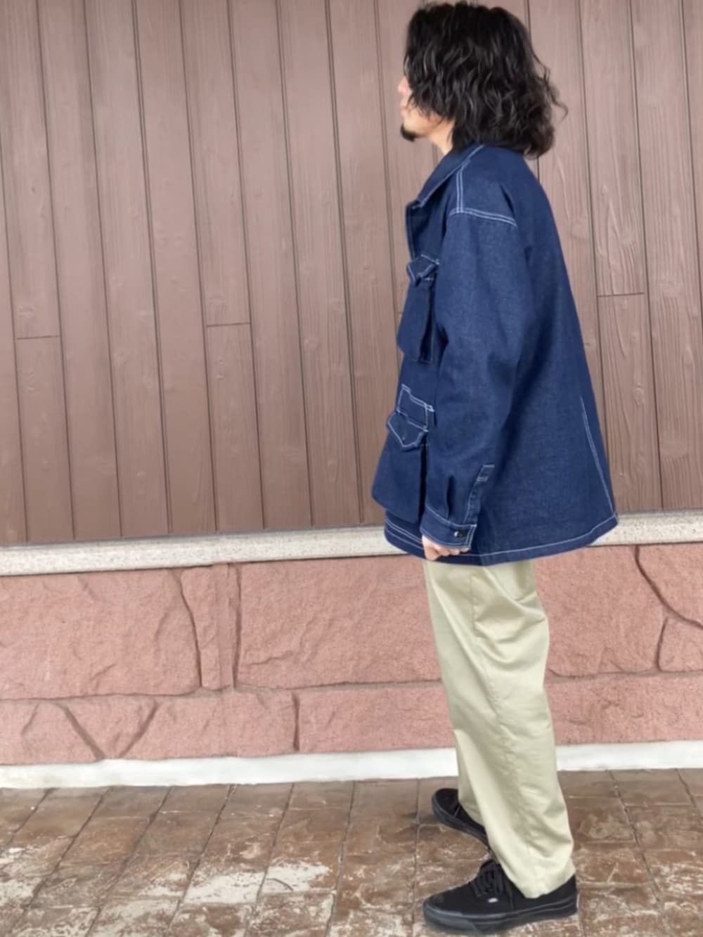 ブラック系のスニーカー、ベージュ系のその他パンツ、ブルー系のカバーオールを着用したメンズの春コーディネートの2枚目の写真