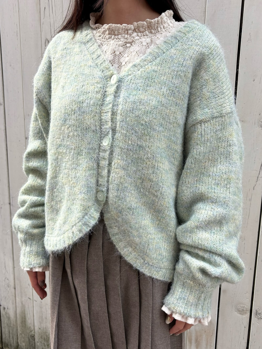 グリーン系のカーディガン/ボレロ、ホワイト系のシャツ/ブラウス、ブラウン系のスカートを着用したレディースの冬コーディネートの2枚目の写真