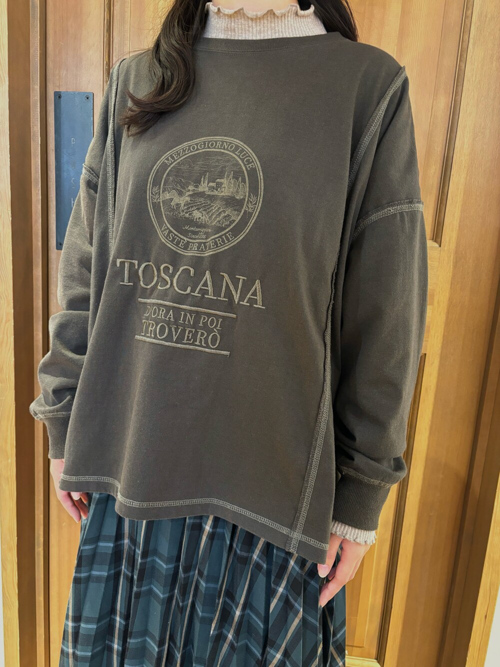 グレー系のTシャツ/カットソー、グリーン系のスカート、ベージュ系のTシャツ/カットソーを着用したレディースの秋コーディネートの2枚目の写真