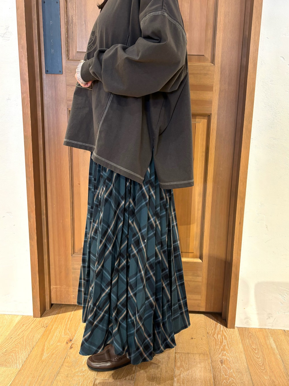 グレー系のTシャツ/カットソー、グリーン系のスカート、ベージュ系のTシャツ/カットソーを着用したレディースの秋コーディネートの3枚目の写真