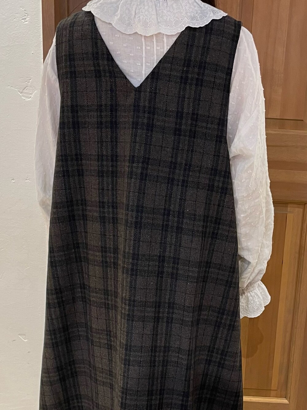 ブルー系のジャンパースカート、ホワイト系のシャツ/ブラウス、ブラウン系のハンドバッグを着用したレディースの秋コーディネートの3枚目の写真