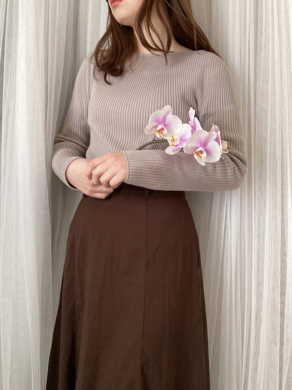 グレー系のニット/セーター、ホワイト系のショルダーバッグ、ホワイト系のパンプスを着用したレディースの春コーディネートの3枚目の写真