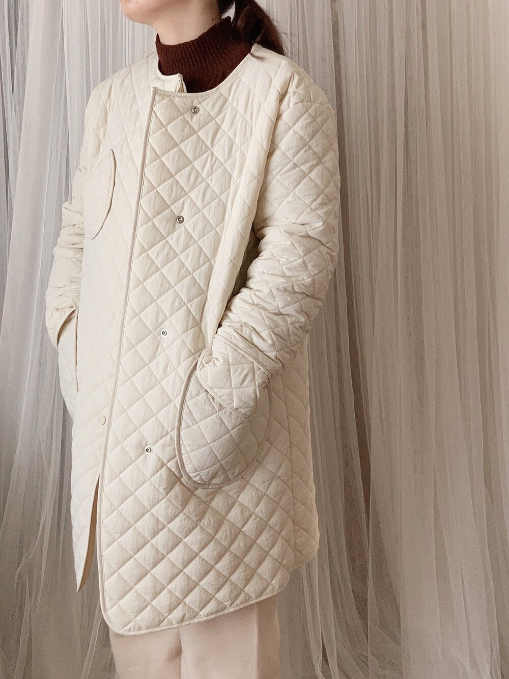 ホワイト系のジャケット/アウター、ブラウン系のニット/セーター、ホワイト系のその他パンツを着用したレディースの冬コーディネートの2枚目の写真