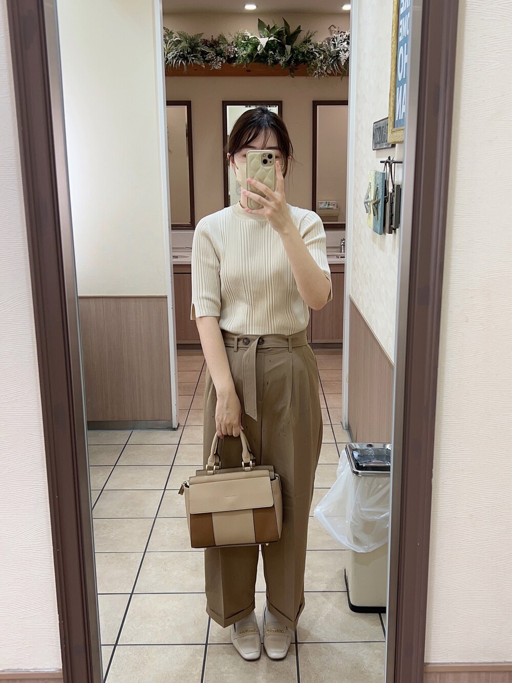 ベージュ系のトートバッグ、ベージュ系のTシャツ/カットソー、ベージュ系のパンツを着用したレディースの秋コーディネートの3枚目の写真